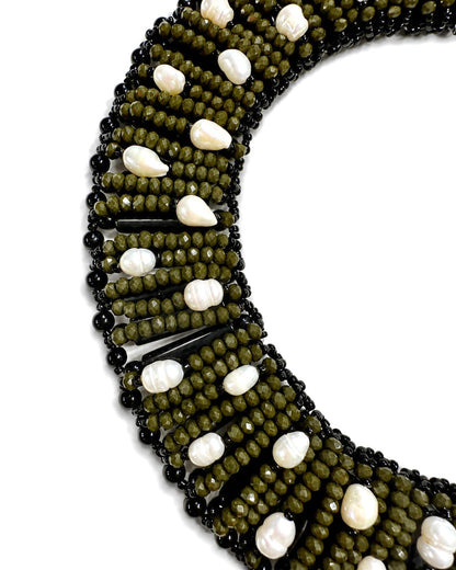 Dettaglio delle perline verde oliva, elementi neri e perle naturali della collana realizzata a mano.