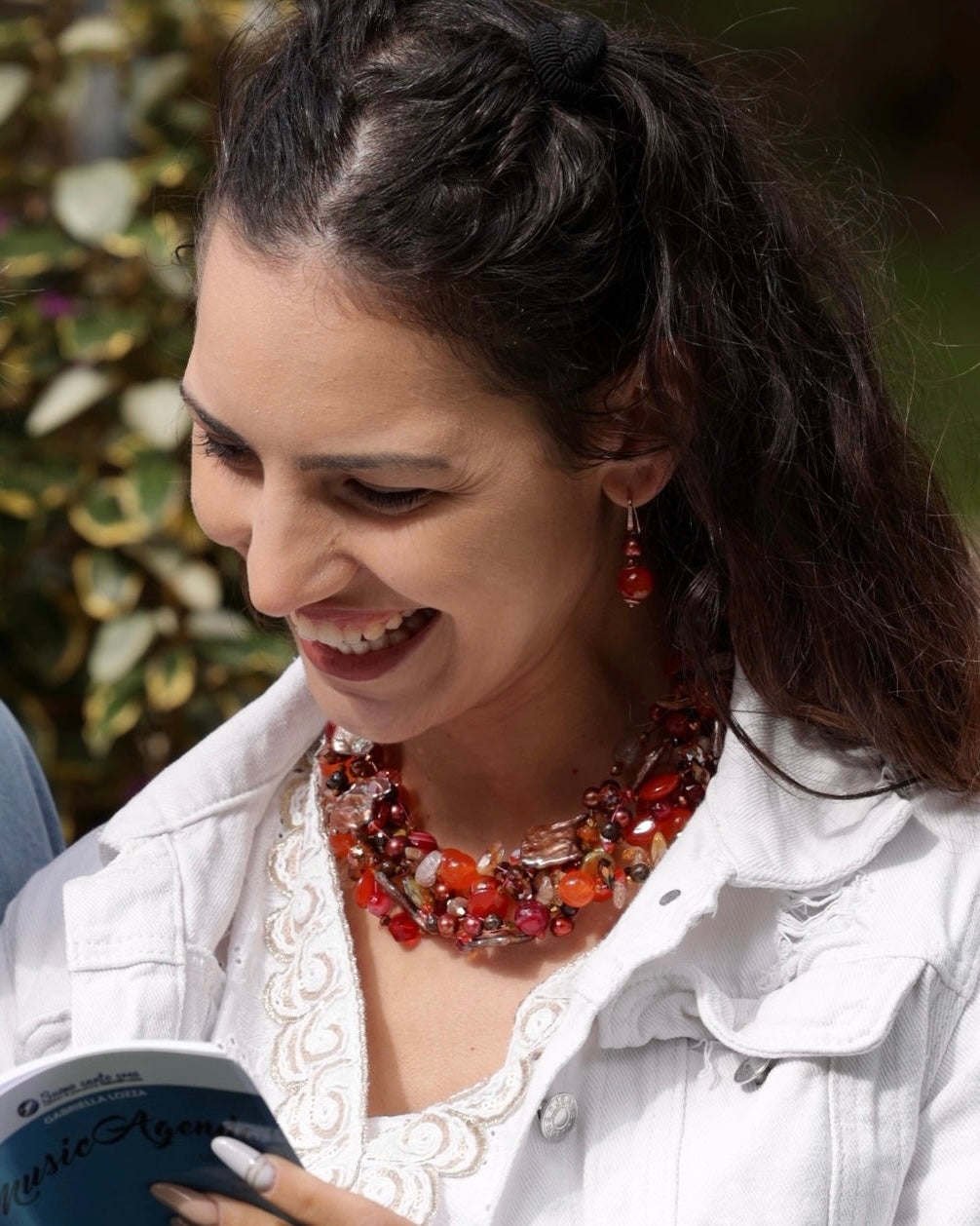 Collana artigianale arancio con pietre naturali e perle indossata su modella, gioiello appariscente Attimi Gioielli