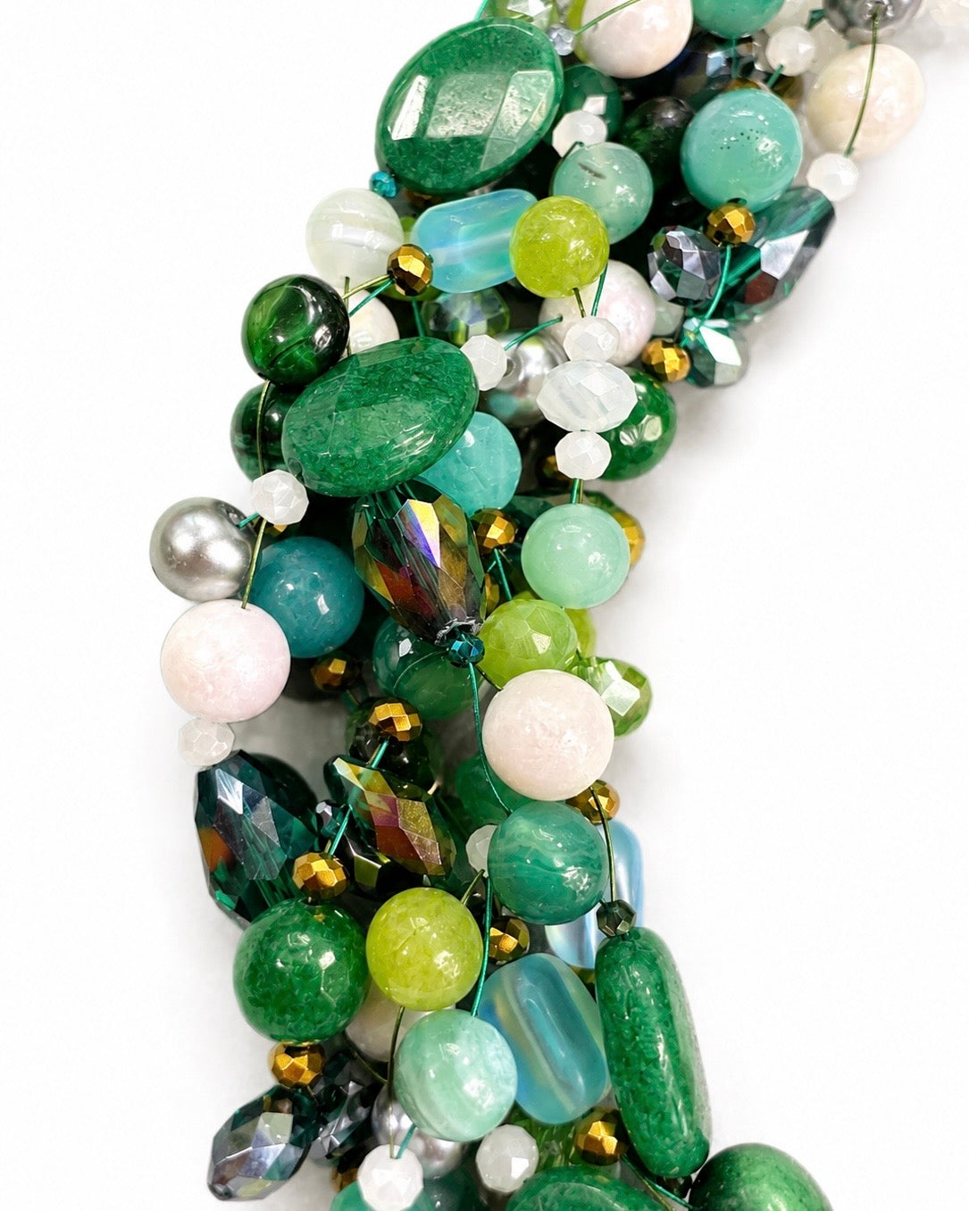 Dettaglio della lavorazione artigianale della collana intrecciata con pietre naturali verdi, cristalli sfaccettati e perle naturali.