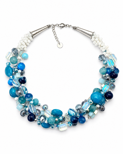     Collana artigianale multifilo con pietre naturali blu e azzurre, cristalli sfaccettati e dettagli in acciaio inox su sfondo bianco.