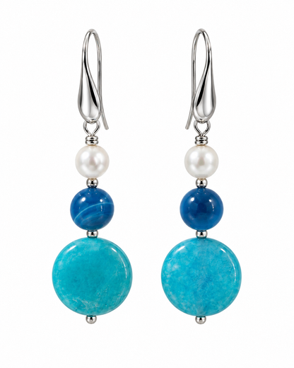     Orecchini in argento 925 con agata blu, giada azzurra, perla Maiorca e palline di ematite su fondo bianco.