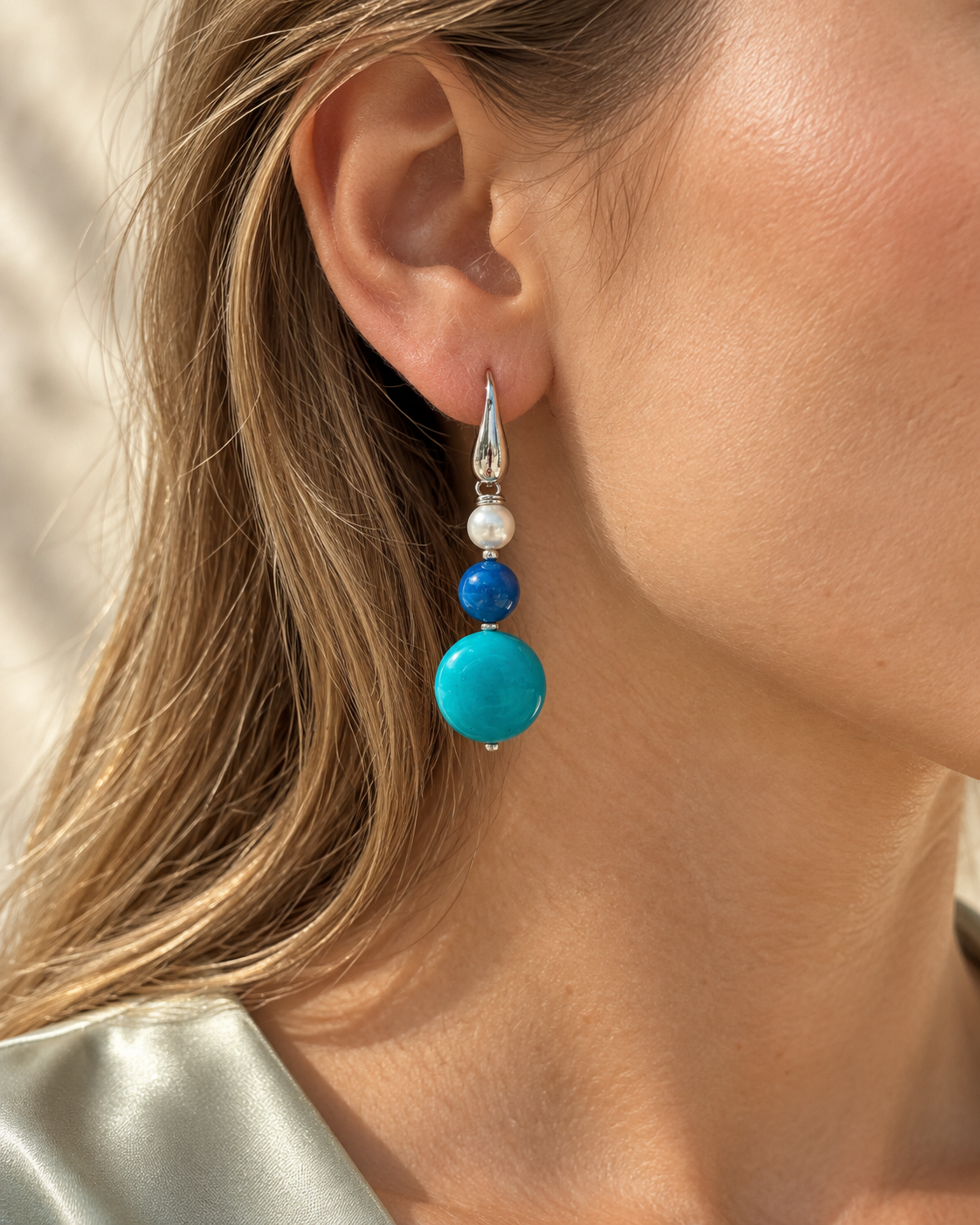     Orecchino pendente in argento 925 con agata blu, giada azzurra e perla Maiorca indossato da una modella.
