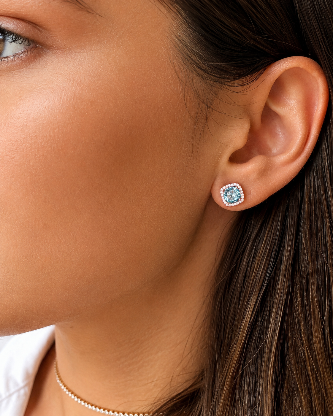 Orecchini a lobo in Argento 925 con moissanite color acquamarina e contorno halo di moissaniti bianche, indossati su modella.