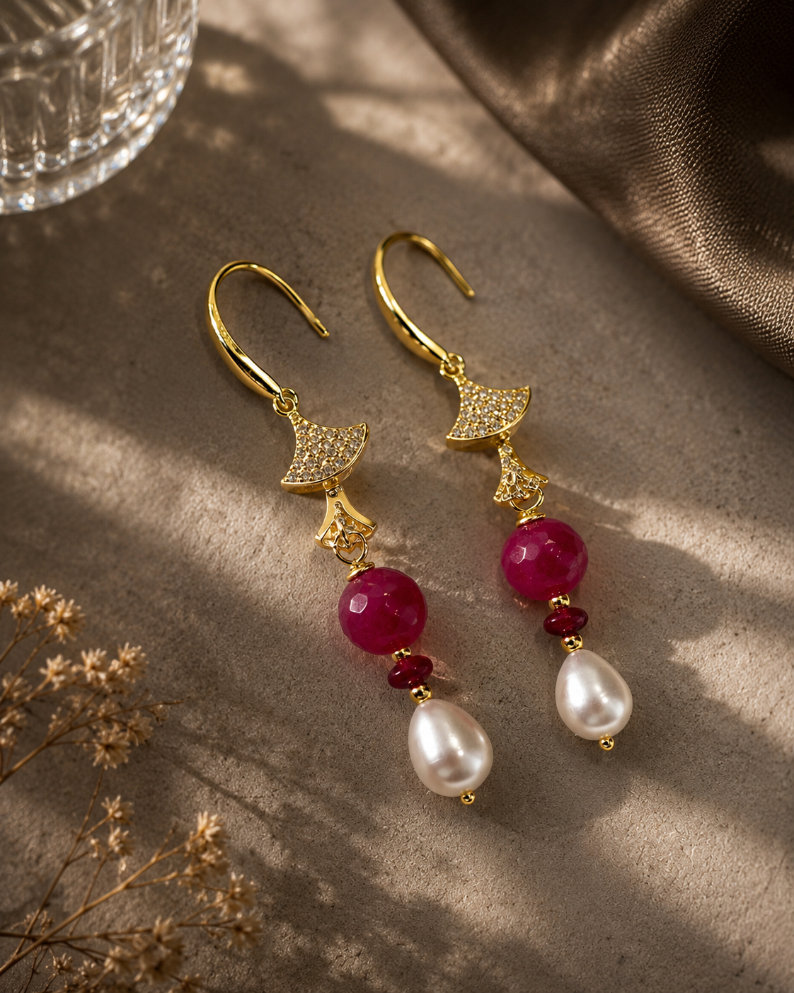 Orecchini pendenti in argento dorato con perle naturali a goccia, pietre dure fucsia sfaccettate e dettagli luminosi. Gioiello elegante e raffinato realizzato a mano. Ambientati