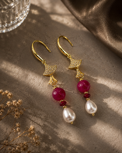 Orecchini pendenti in argento dorato con perle naturali a goccia, pietre dure fucsia sfaccettate e dettagli luminosi. Gioiello elegante e raffinato realizzato a mano. Ambientati