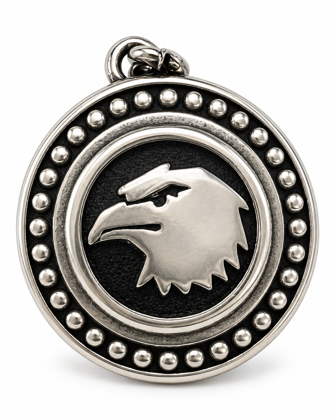 Dettaglio del medaglione del portachiavi in acciaio inox con aquila in rilievo su fondo nero e cornice decorata con piccoli elementi rotondi.
