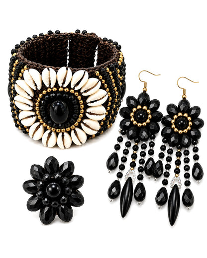 Set completo boho composto da bracciale con conchiglie naturali, anello fiore nero e orecchini pendenti neri con dettagli dorati.