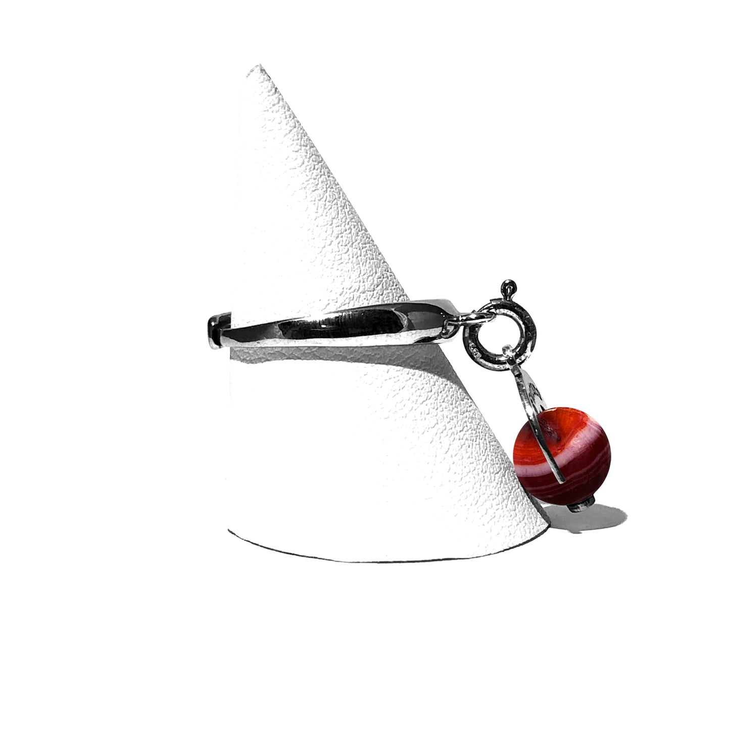 Caratteristiche: L'anello è composto da una base in Argento 925 e un Charm Naja. Quest'ultimo è inciso e smaltato, con scritte in carattere gotico e una Pietra Dura. Il Charm è attaccato alla base dell'anello con un piccolo moschettone che permette l'eventuale riposizionamento del charm stesso su un bracciale , una collana o un qualsiasi altro supporto