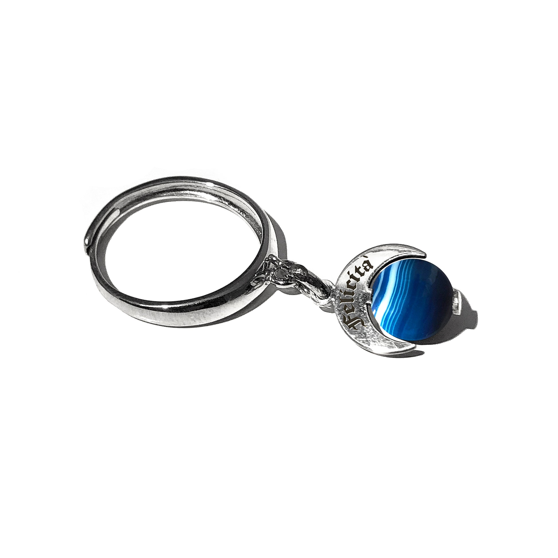 Caratteristiche: L'anello è composto da una base in Argento 925 e un Charm Naja. Quest'ultimo è inciso e smaltato, con scritte in carattere gotico e una Pietra Dura. Il Charm è attaccato alla base dell'anello con un piccolo moschettone che permette l'eventuale riposizionamento del charm stesso su un bracciale , una collana o un qualsiasi altro supporto.