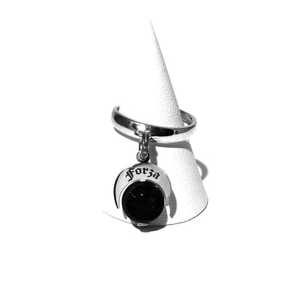 Caratteristiche: L'anello è composto da una base in Argento 925 e un Charm Naja. Quest'ultimo è inciso e smaltato, con scritte in carattere gotico e una Pietra Dura. Il Charm è attaccato alla base dell'anello con un piccolo moschettone che permette l'eventuale riposizionamento del charm stesso su un bracciale , una collana o un qualsiasi altro supporto